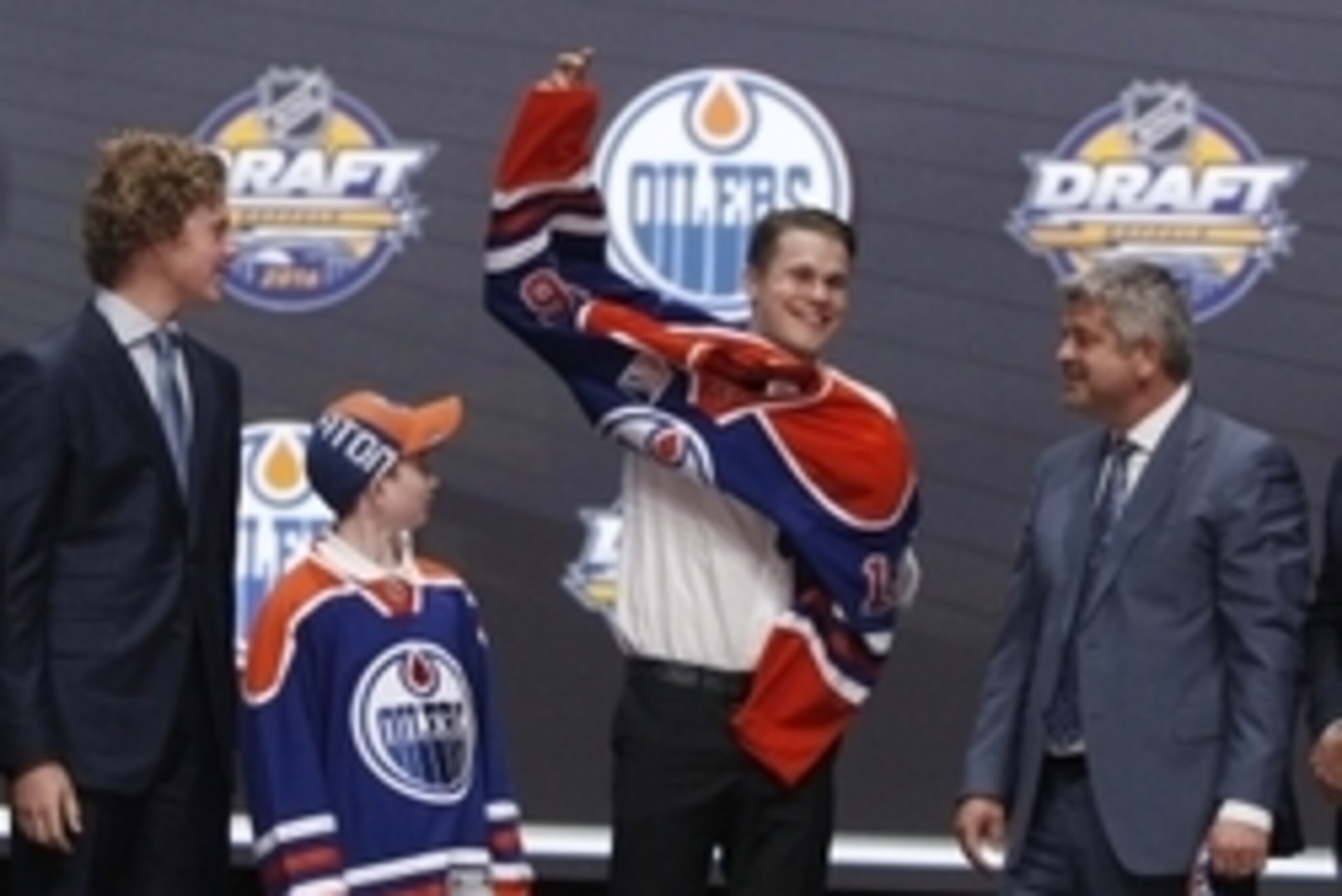 Jun 24, 2016; Buffalo, NY, USA; Jesse Puljujarvi puts on a team jersey after being selected as the number four overall draft pick by the Edmonton Oilers in the first round of the 2016 NHL Draft at the First Niagra Center. Mandatory Credit: Timothy T. Ludw