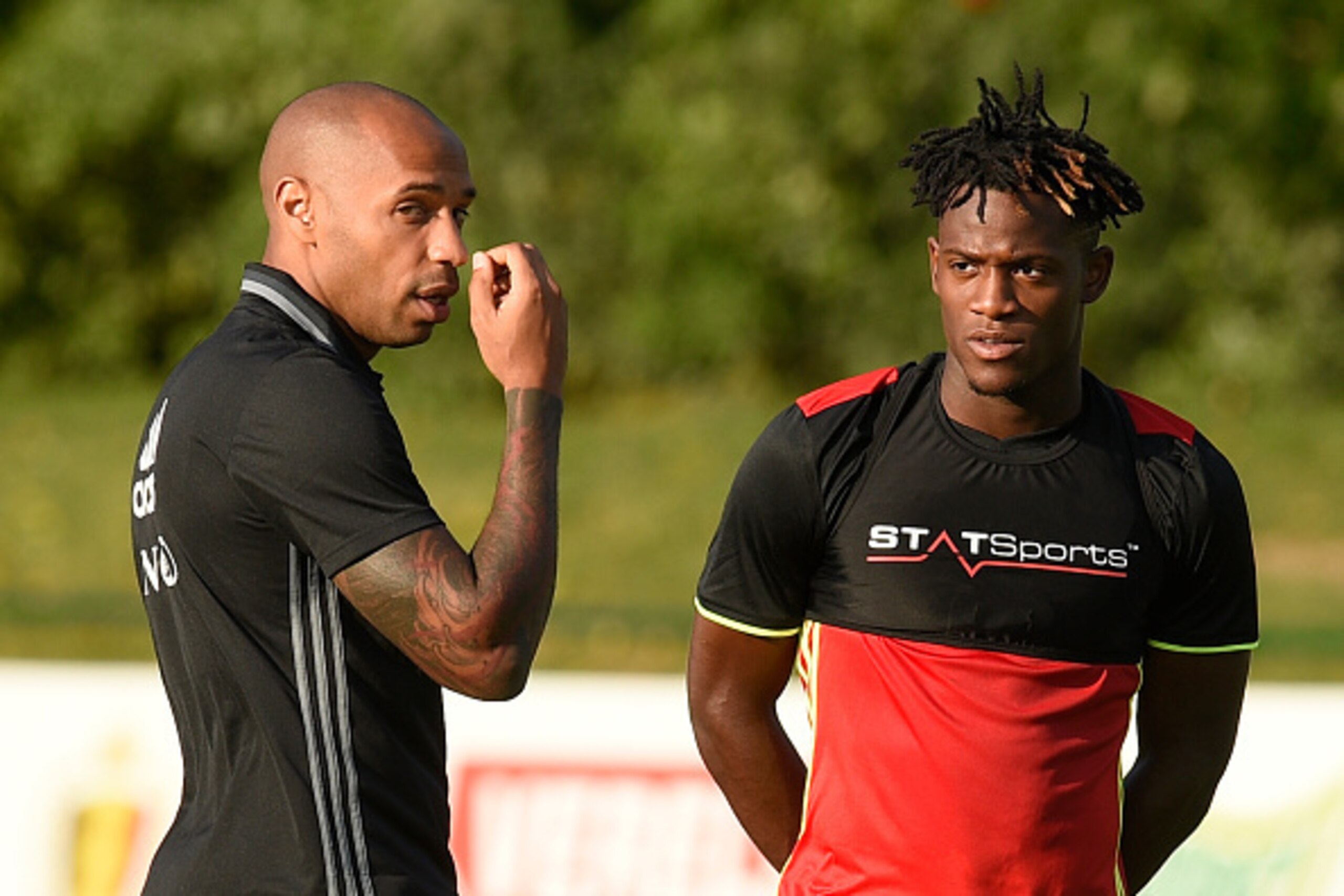 Belgium's national team assistant coach Thierry Henry (L) gestures as he talks with Belgium's forward Michy Batshuayi during a training session, three days before their football match against Spain, in Neerpede on August 29, 2016. / AFP / JOHN THYS Belgium's national team assistant coach Thierry Henry (L) gestures as he talks with Belgium's forward Michy Batshuayi during a training session, three days before their football match against Spain, in Neerpede on August 29, 2016. / AFP / JOHN THYS