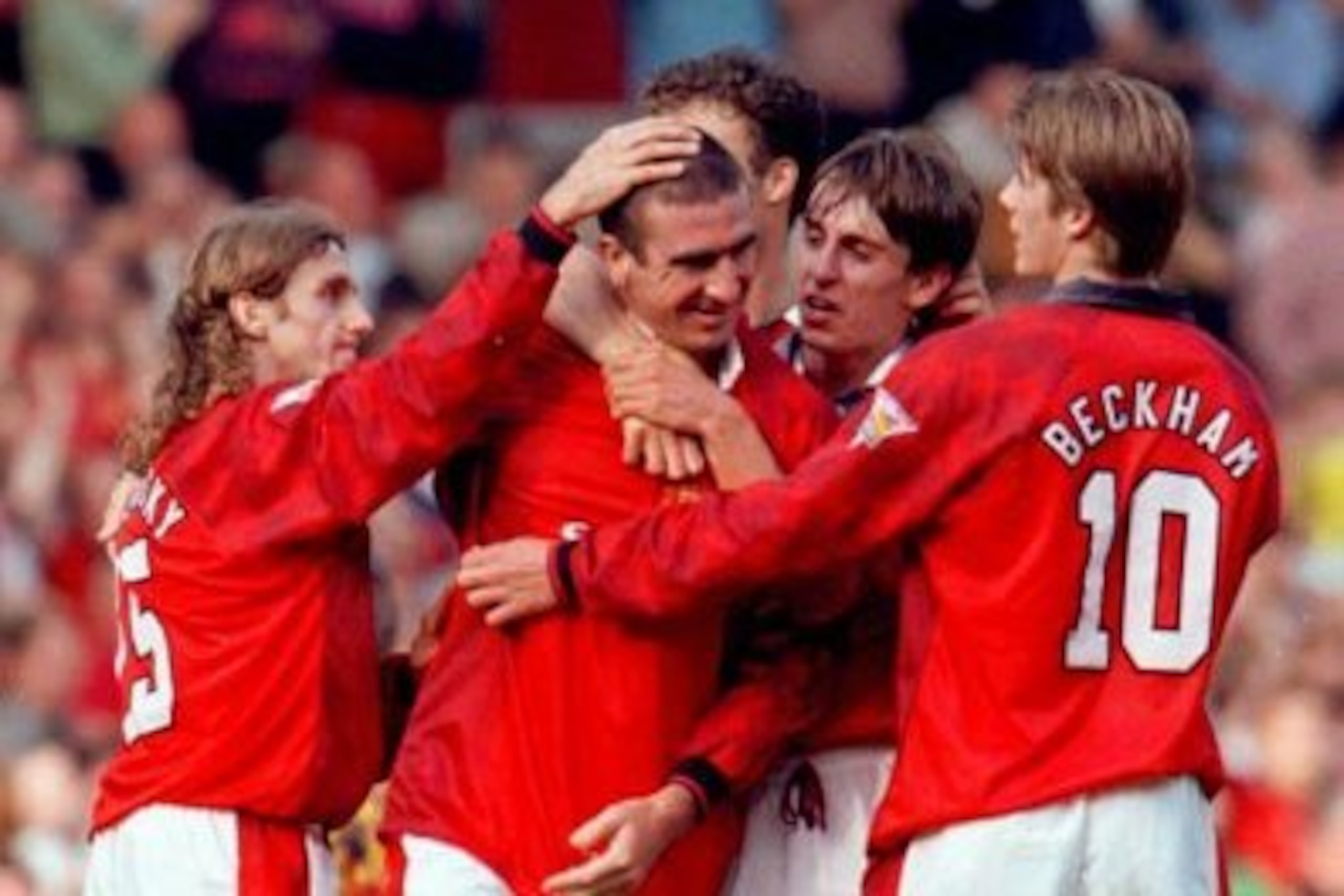 Cantona is mobbed by United players following another goal.