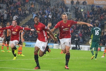 Manchester United's English striker Marcus Rashford (2nd L) celebrates with Manchester United's Swedish striker Zlatan Ibrahimovic after scoring their late winning goal during the English Premier League football match between Hull City and Manchester Unit