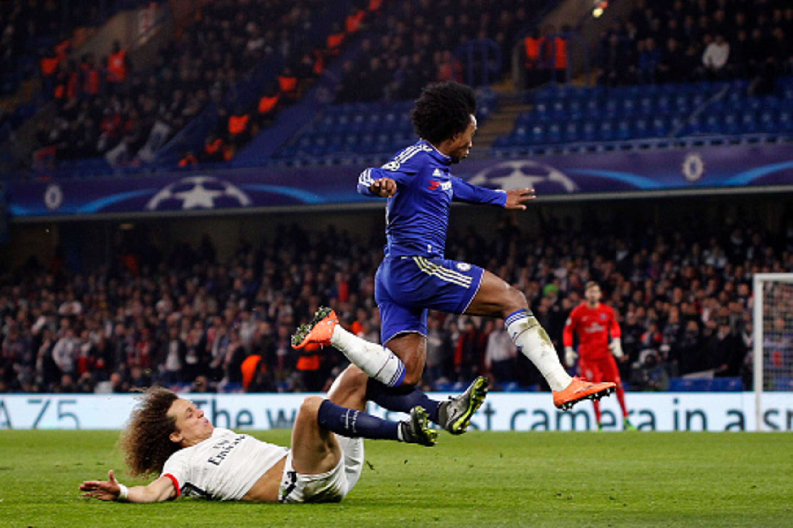 LONDON, ENGLAND - MARCH 09: Willian of Chelsea avoids a sliding tackle from David Luiz of PSG during the UEFA Champions League round of 16 second leg match between Chelsea FC and Paris Saint-Germain at Stamford Bridge on March 09, 2016 in London, United K LONDON, ENGLAND - MARCH 09: Willian of Chelsea avoids a sliding tackle from David Luiz of PSG during the UEFA Champions League round of 16 second leg match between Chelsea FC and Paris Saint-Germain at Stamford Bridge on March 09, 2016 in London, United K