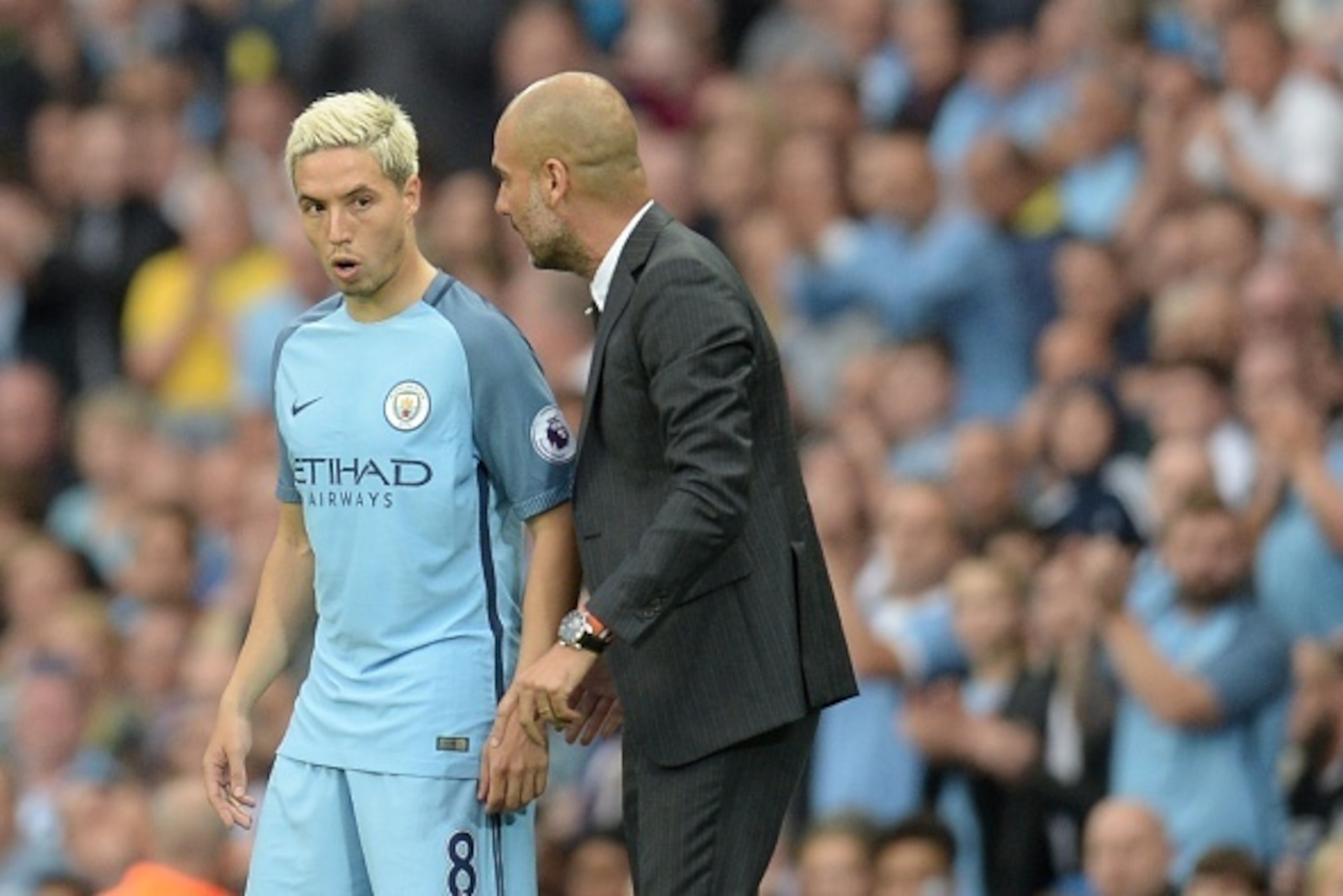 Manchester City's Spanish manager Pep Guardiola talks to Manchester City's French midfielder Samir Nasri (L) as he prepares to come on during the English Premier League football match between Manchester City and West Ham United at the Etihad Stadium in Ma
