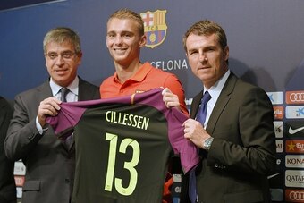 FC Barcelona's Dutch goalkeeper Jasper Cillessen (C) poses with his new jersey flanked by Barcelona's third Vice-President Jordi Mestre (L) and Barcelon's general manager Robert Fernandez after his official presentation at the Camp Nou stadium in Barcelon