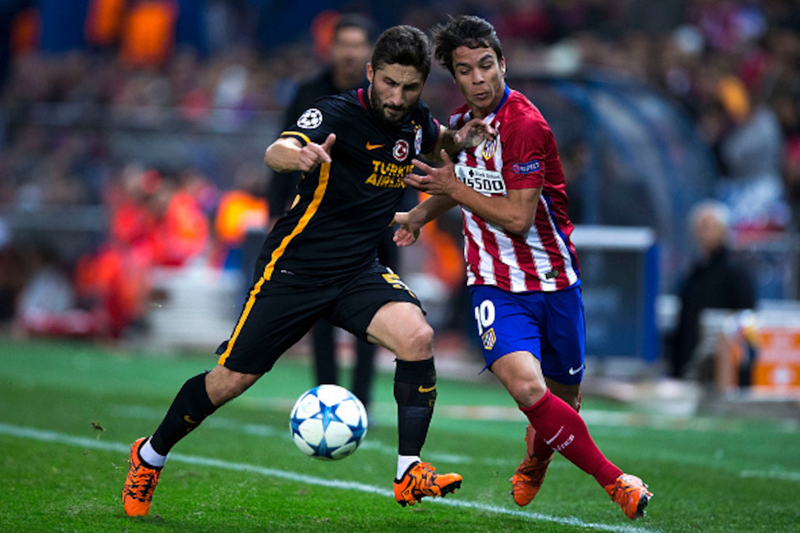 MADRID, SPAIN - NOVEMBER 25: Sabri Sariouglu (L) of Galatasaray AS competes for the ball with Oliver Torres (R) of Atletico de Madrid during the UEFA Champions League Group C match between Club Atletico de Madrid and Galatasaray AS at Estadio Vicente Cald