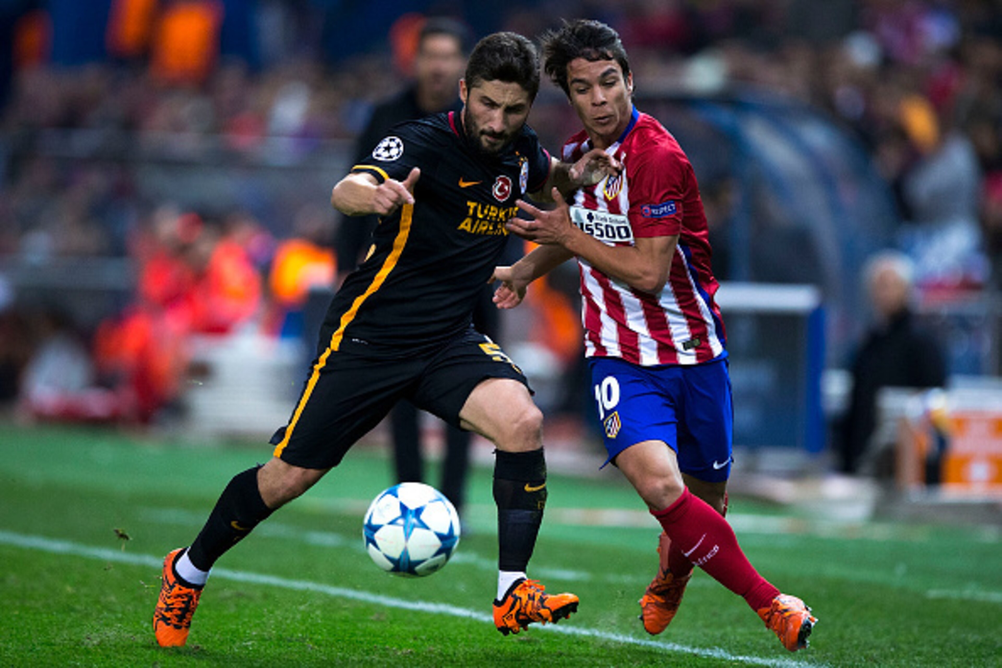 MADRID, SPAIN - NOVEMBER 25: Sabri Sariouglu (L) of Galatasaray AS competes for the ball with Oliver Torres (R) of Atletico de Madrid during the UEFA Champions League Group C match between Club Atletico de Madrid and Galatasaray AS at Estadio Vicente Cald