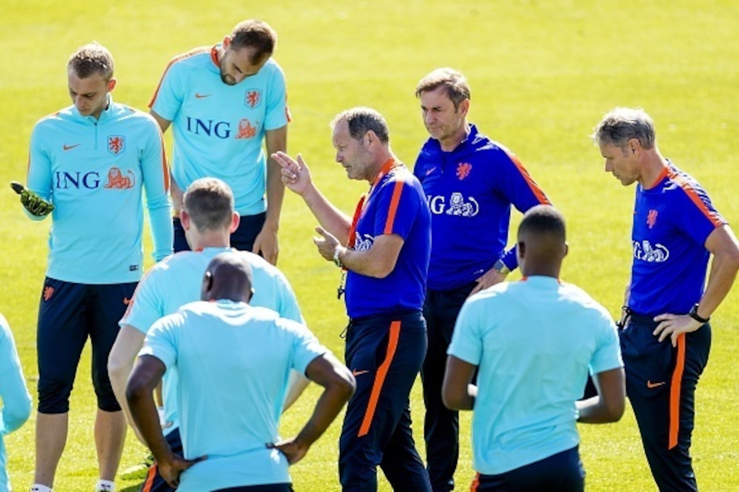 Netherlands national football team head coach Danny Blind (C) speaks to players, as his assistant Marco van Basten (R) looks on, during a training session in Katwijk on August 30, 2016. 
The Netherlands will face Greece in friendly match on September 1 an