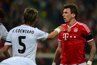 Bayern Munich's Croatian striker Mario Mandzukic (R) and Real Madrid's Portuguese defender Fabio Coentrao vie for the ball during the UEFA Champions League second-leg semi-final football match FC Bayern Munich vs Real Madrid CF in Munich, southern Germany