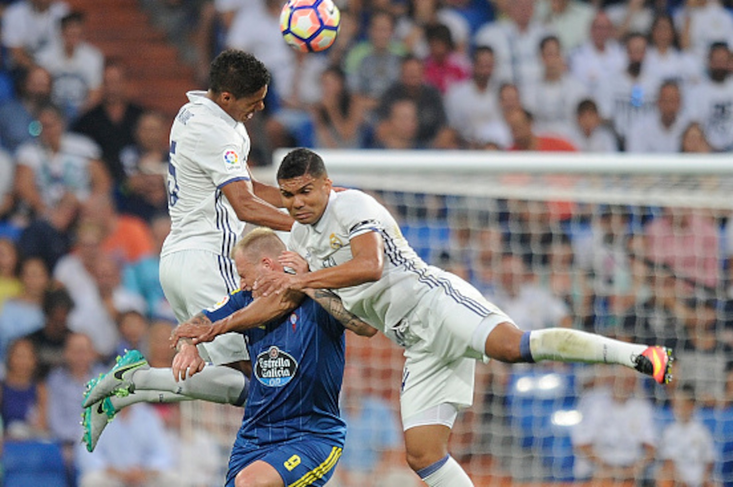 MADRID, SPAIN - AUGUST 27:  Henrique Casemiro and Rafael Varane of Real Madrid clash with John Guidetti of RC Celta de Vigo during the La Liga match between Real Madrid CF and RC Celta de Vigo at Estadio  Santiago Bernabeu on August 27, 2016 in Madrid, Sp