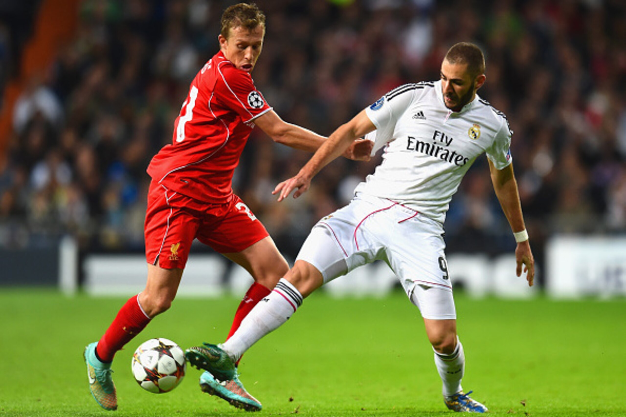 MADRID, SPAIN - NOVEMBER 04:  Lucas Leiva of Liverpool is challenged by Karim Benzema of Real Madrid CF during the UEFA Champions League Group B match between Real Madrid CF and Liverpool FC at Estadio Santiago Bernabeu on November 4, 2014 in Madrid, Spai