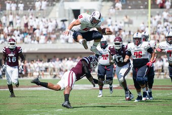 STARKVILLE, MS - SEPTEMBER 3: Quarterback Dallas Davis #11 of the South Alabama Jaguars leaps over defensive back Brandon Bryant #1 of the Mississippi State Bulldogs for a first down at Davis Wade Stadium on September 3, 2016 in Starkville, Mississippi. T
