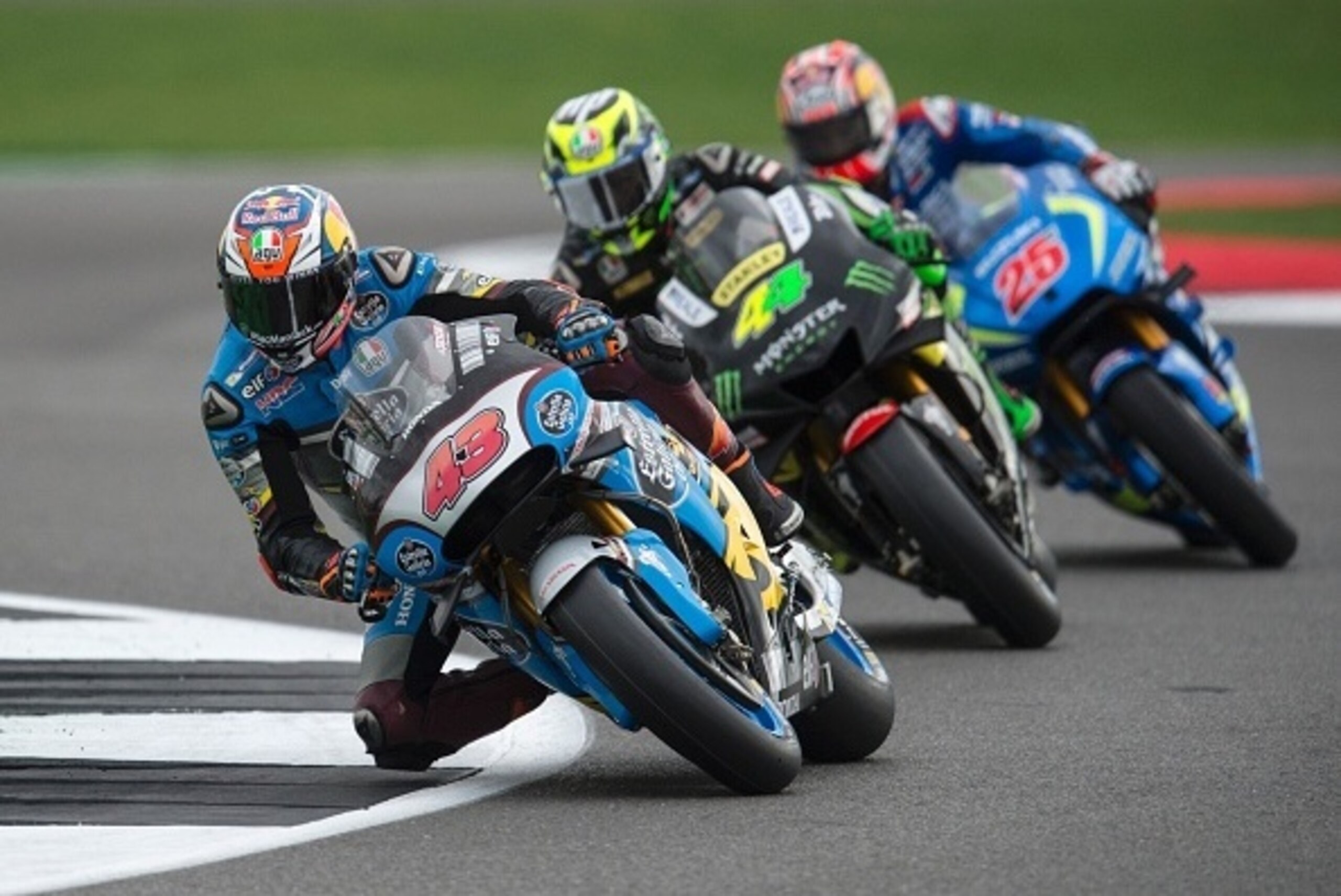 Marc VDS Racing Team's Australian rider Jack Miller (L) leads Monster Yamaha Tech 3's Spanish rider Pol Espargaro (C) and Team Suzuki Ecstar's Spanish rider Maverick Vinales through Vale Corner during the MotoGP Warm Up session at the motorcycling British