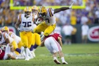 Sep 3, 2016; Green Bay, WI, USA;   LSU Tigers running back Leonard Fournette (7) leaps over Wisconsin Badgers safety Leo Musso (19) during the fourth quarter at Lambeau Field. Mandatory Credit: Jeff Hanisch-USA TODAY Sports
