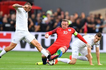 England's forward Wayne Rooney (C) is tackled by Slovakia's midfielder Marek Hamsik (L) and Slovakia's midfielder Jan Gregus during the World Cup 2018 football qualification match between Slovakia and England in Trnava on September 4, 2016.  / AFP / JOE K