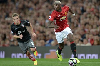 Manchester United's French midfielder Paul Pogba (R) runs with the ball during the English Premier League football match between Manchester United and Southampton at Old Trafford in Manchester, north west England, on August 19, 2016. / AFP / Oli SCARFF / 