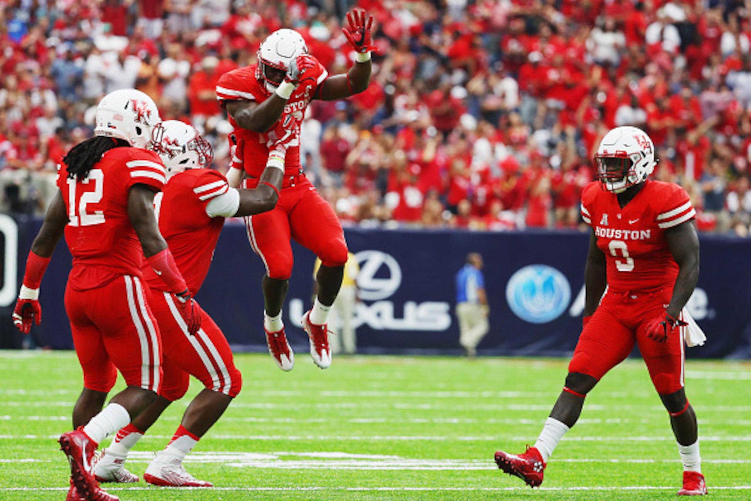 HOUSTON, TX - SEPTEMBER 03:  Brandon Wilson #26 of the Houston Cougars leaps into the air near his teammates during the second half of their game against the Oklahoma Sooners during the Advocare Texas Kickoff on September 3, 2016 in Houston, Texas.  (Phot