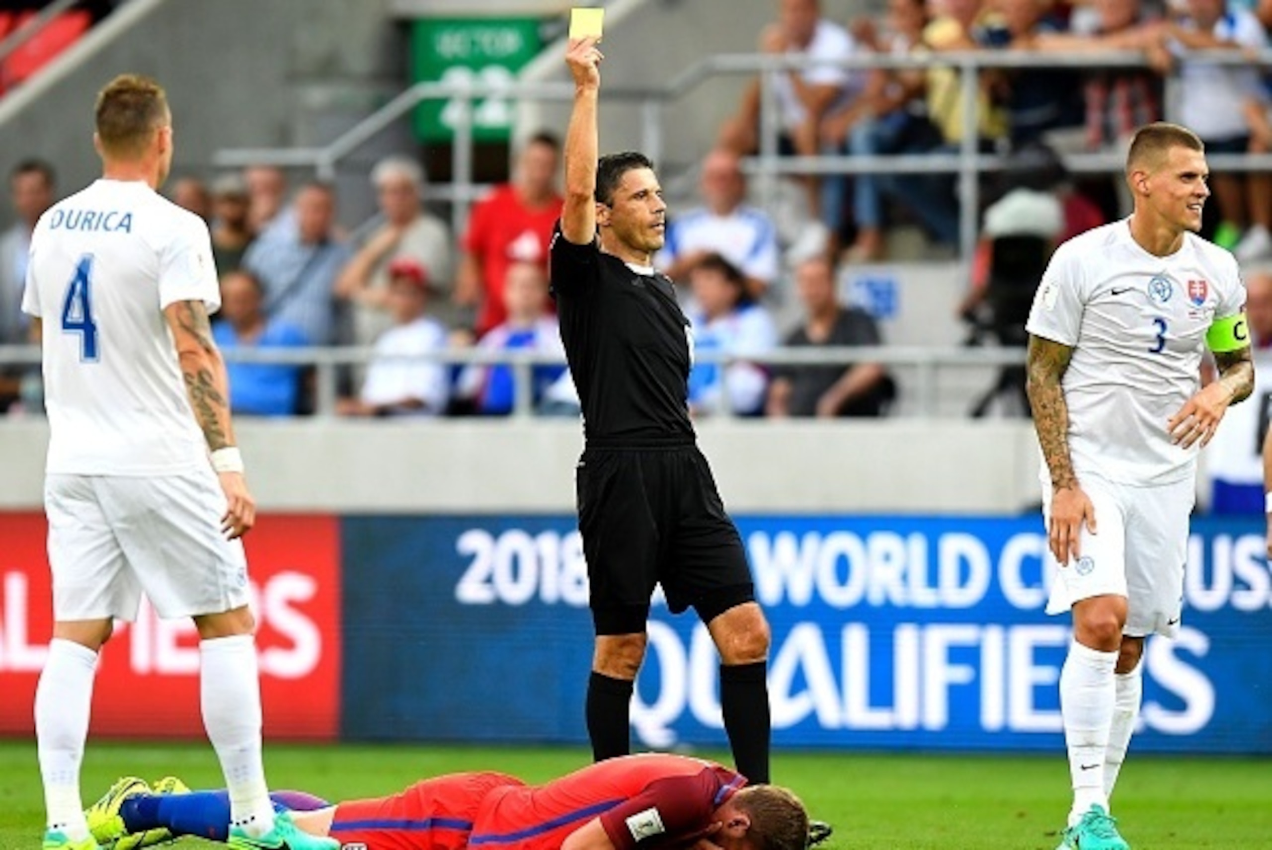 Slovakia's defender Martin Skrtel (R) receives his first yellow card during the World Cup 2018 football qualification match between Slovakia and England in Trnava, Slovakia, on September 4, 2015.  / AFP / JOE KLAMAR        (Photo credit should read JOE KL
