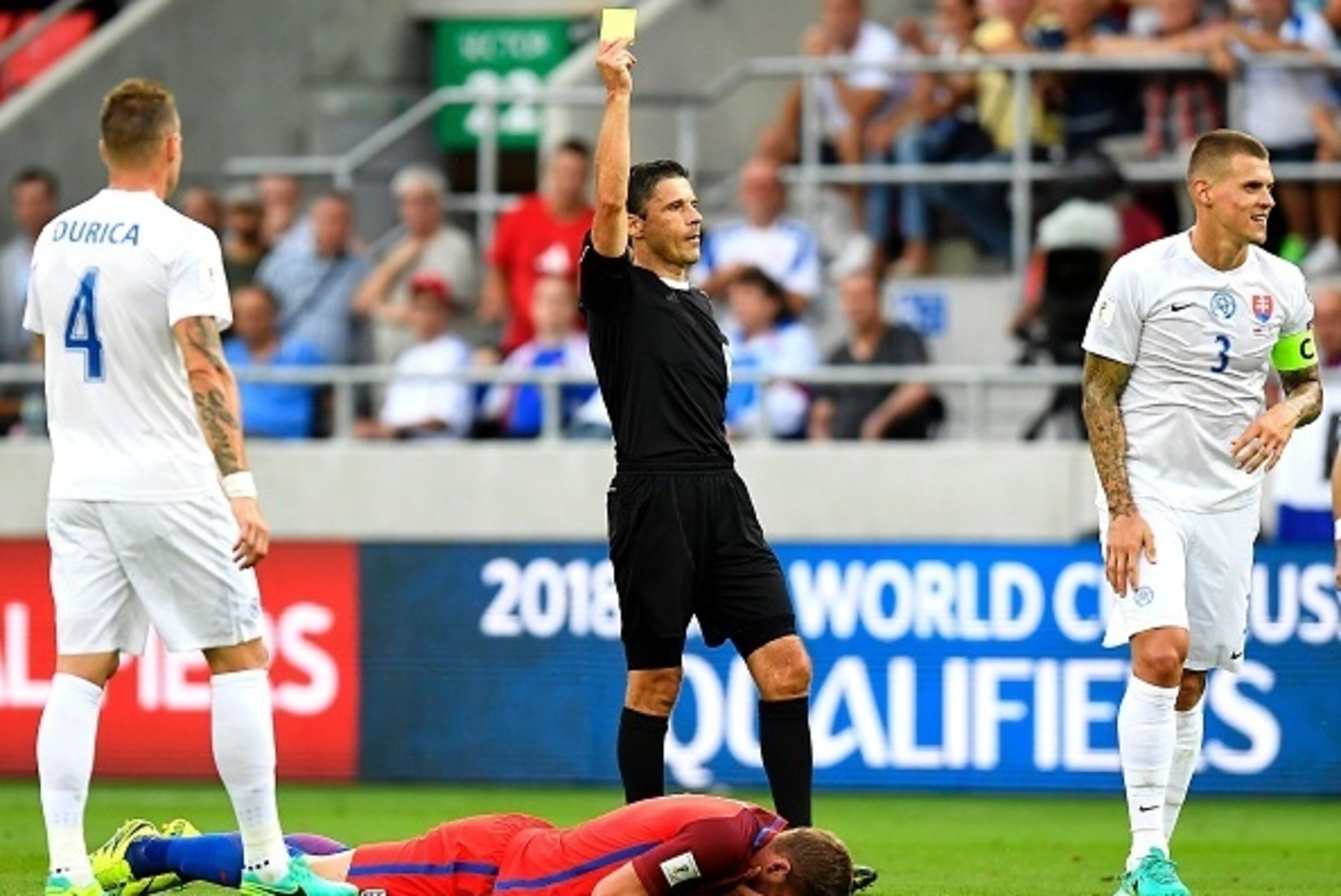 Slovakia's defender Martin Skrtel (R) receives his first yellow card during the World Cup 2018 football qualification match between Slovakia and England in Trnava, Slovakia, on September 4, 2015.  / AFP / JOE KLAMAR        (Photo credit should read JOE KL