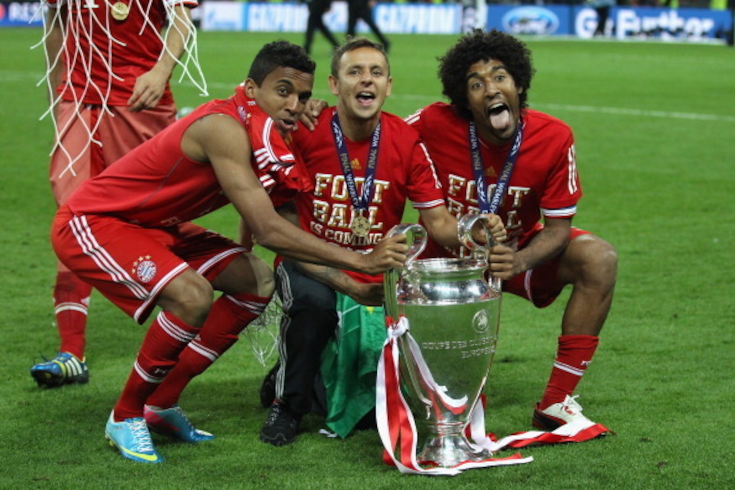LONDON, ENGLAND - MAY 25:  (L-R) Luiz Gustavo, Rafinha and Dante of Bayern Muenchen celebrate with the trophy after winning the UEFA Champions League final match against Borussia Dortmund at Wembley Stadium on May 25, 2013 in London, United Kingdom.  (Pho