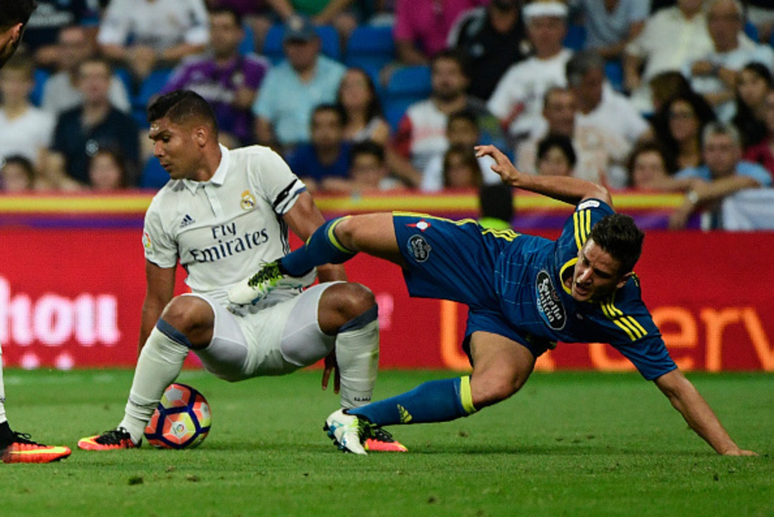 Real Madrid's Brazilian midfielder Casemiro (L) vies with Celta Vigo's Chilean forward Fabian Orellana during the Spanish league football match Real Madrid CF vs RC Celta de Vigo at the Santiago Bernabeu stadium in Madrid on August 27, 2016. / AFP / PIERR