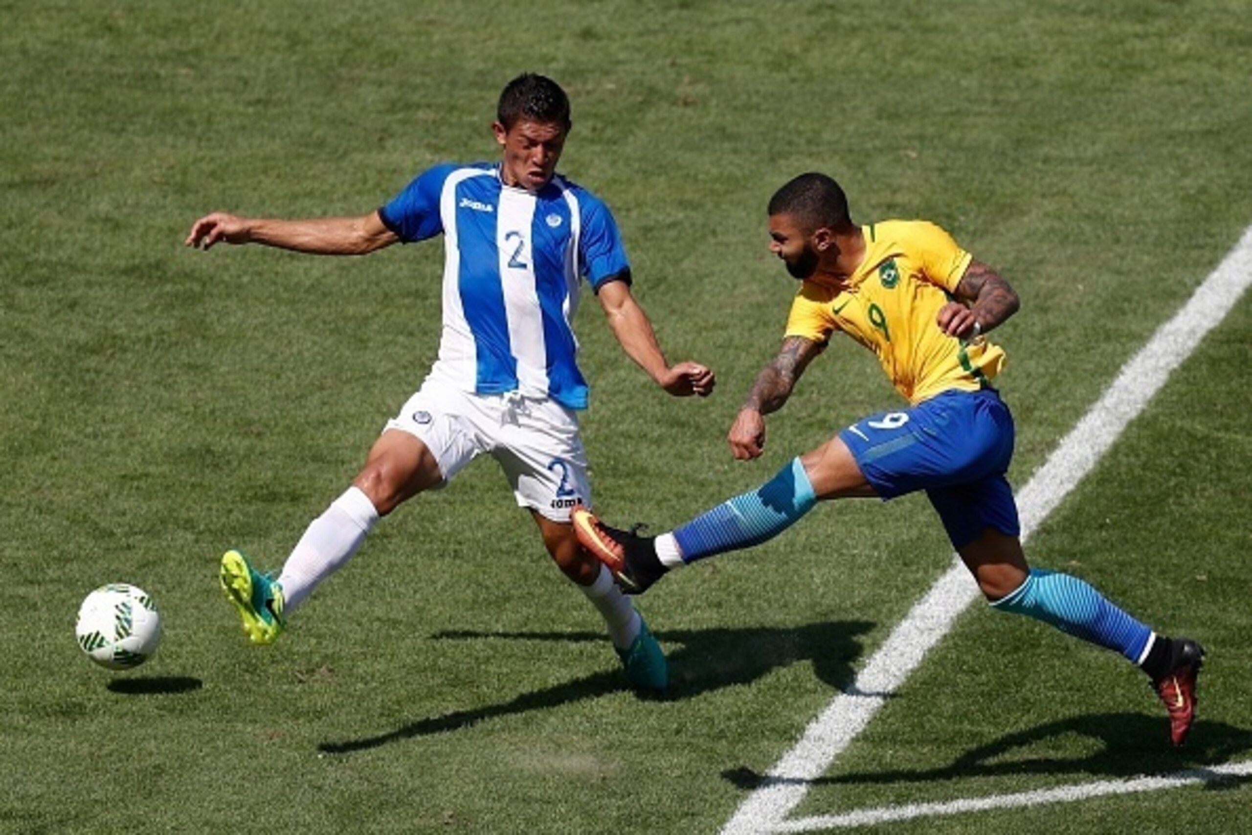 Brazil's Gabriel Barbosa (R) strikes the ball past Honduras' Jhonathan Paz during their Rio 2016 Olympic Games men's football semifinal match at the Maracana stadium in Rio de Janeiro, Brazil, on August 17, 2016. / AFP / Odd Andersen        (Photo credit 