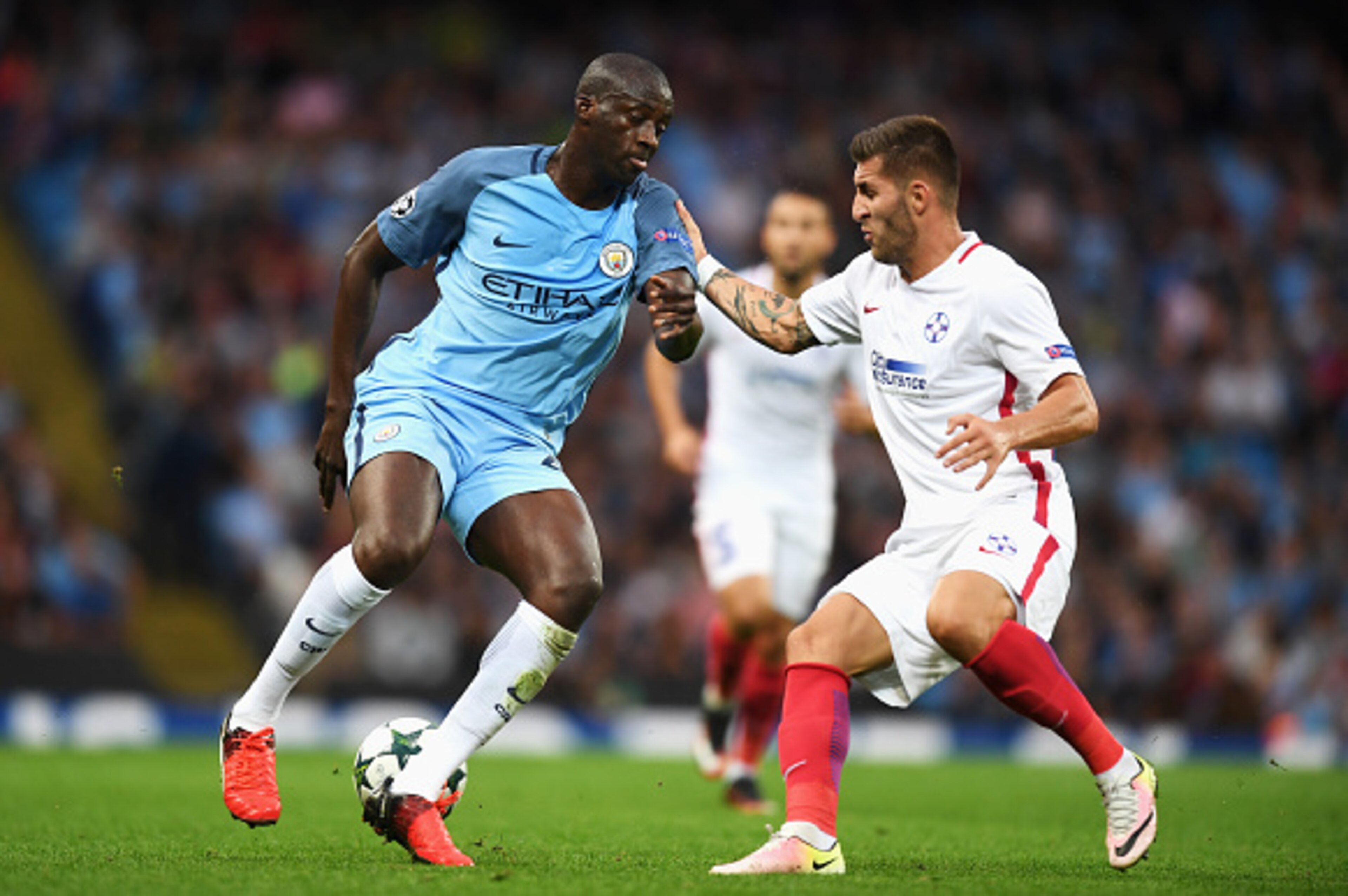 MANCHESTER, ENGLAND - AUGUST 24:  Yaya Toure of Manchester City is closed down by Ovidiu Popescu of Steaua Bucharest during the UEFA Champions League Play-off Second Leg match between Manchester City and Steaua Bucharest at Etihad Stadium on August 24, 20
