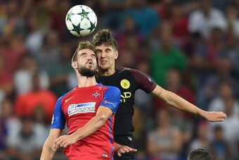 John Stones (R) of Manchester City vies with Alexandru Tudorie of Steaua Bucharest during the UEFA Champions league first leg play-off football match between Steaua Bucharest and Manchester City at the National Arena stadium in Bucharest on August 16, 201