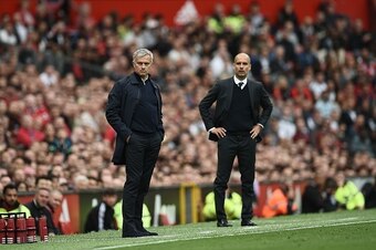 Manchester United's Portuguese manager Jose Mourinho (L) and Manchester City's Spanish manager Pep Guardiola (R) watch from the touchline during the English Premier League football match between Manchester United and Manchester City at Old Trafford in Man