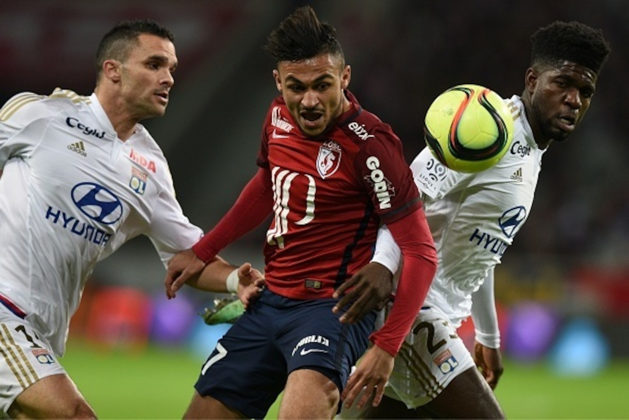Lille's French midfielder Sofiane Boufal (C) vies with Lyon's French Cameroonian defender Samuel Umtiti (R) and Lyon's French defender Jeremy Morel during the French L1 football match between Lille (LOSC) and Lyon (OL) on February 21, 2016, at Lille Pierr