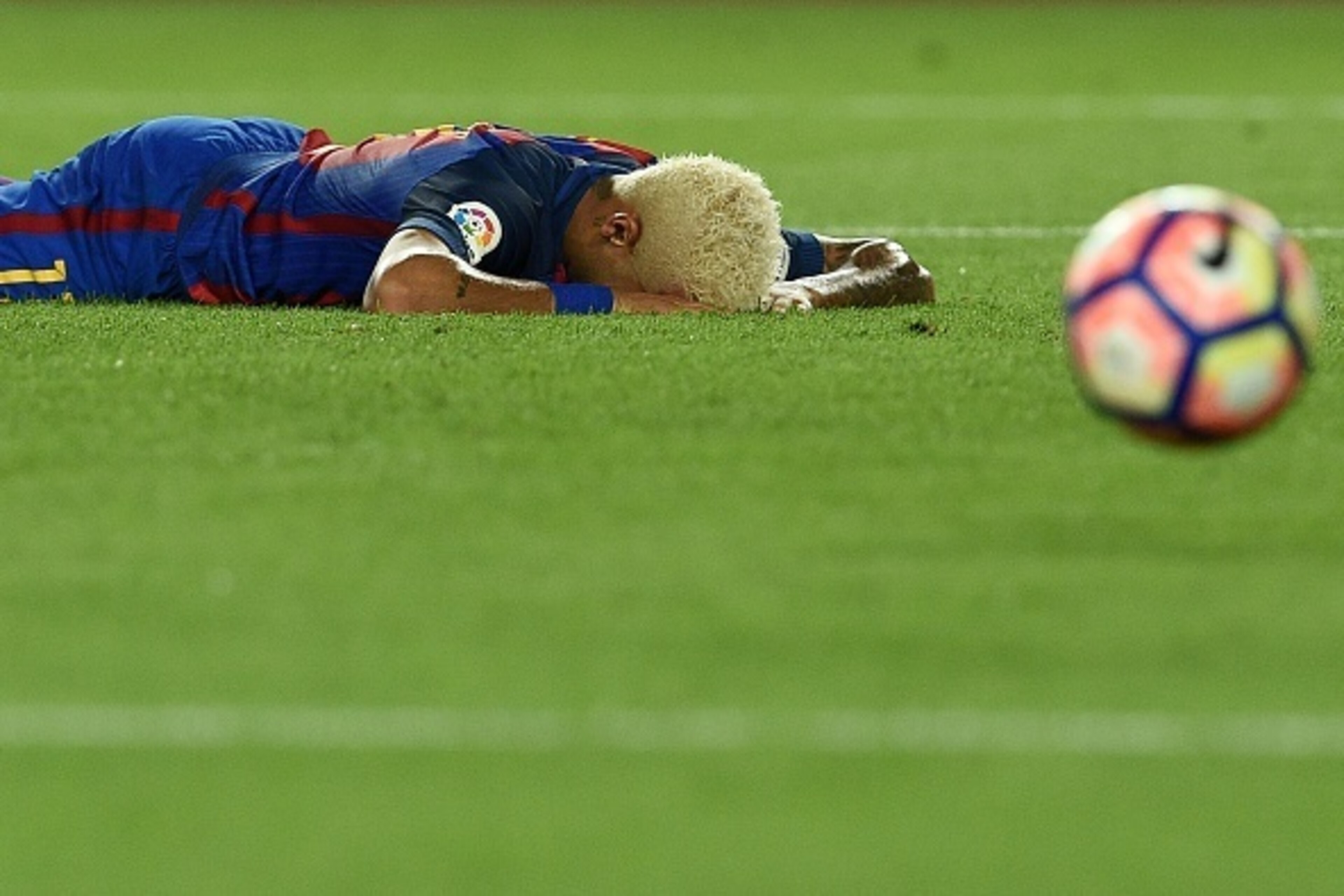 Barcelona's Brazilian forward Neymar lies on the pitch after missing a goal during the Spanish league football match FC Barcelona vs Deportivo Alaves at the Camp Nou stadium in Barcelona on September 10, 2016. / AFP / LLUIS GENE        (Photo credit shoul