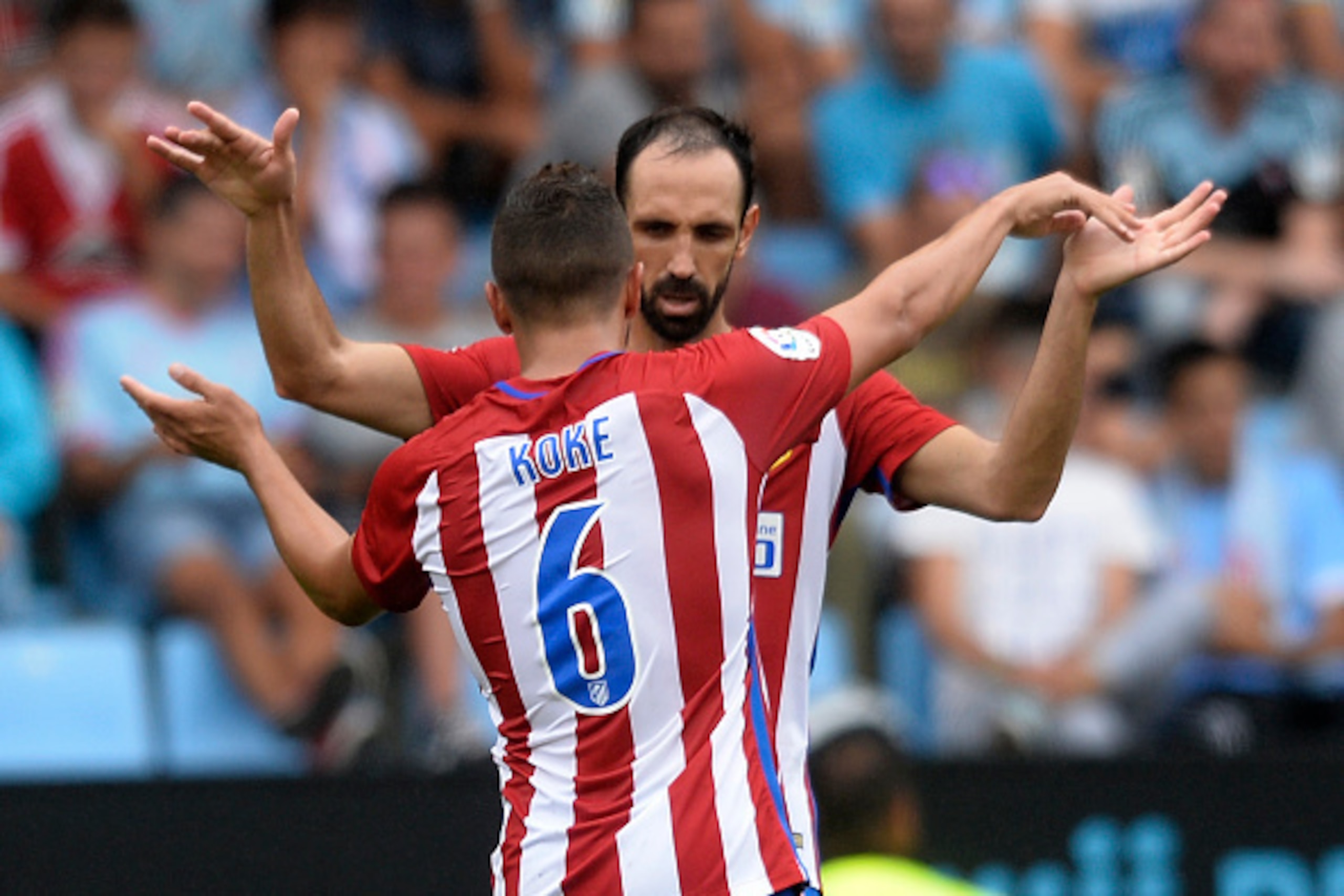 Atletico Madrid's midfielder Koke (L) celebrates with teammate Uruguayan defender Diego Godin after scoring during the Spanish league football match RC Celta de Vigo vs Club Atletico de Madrid at the Balaidos stadium in Vigo on September 10, 2016.
Atletic