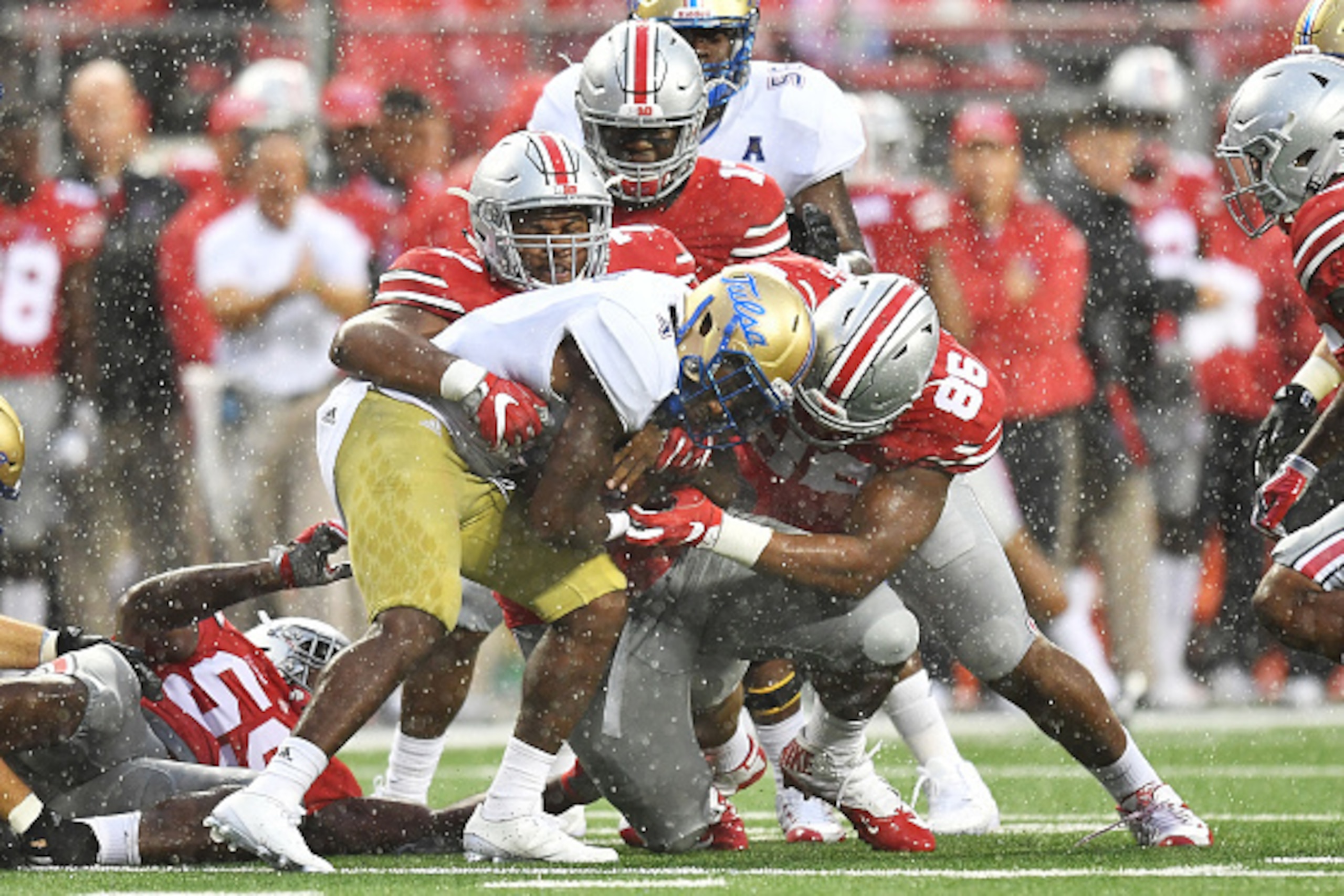 COLUMBUS, OH - SEPTEMBER 10:  D'Angelo Brewer #4 of the Tulsa Hurricane is wrapped up for no gain by Michael Hill #77 of the Ohio State Buckeyes and Dre'Mont Jones #86 of the Ohio State Buckeyes in the third quarterat Ohio Stadium on September 10, 2016 in