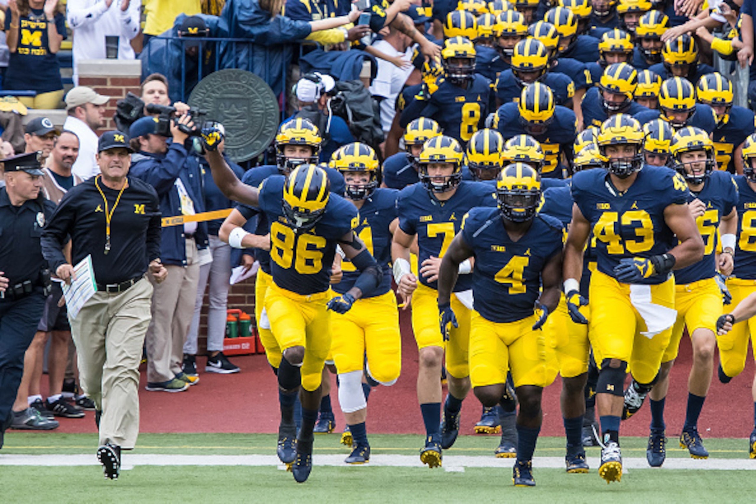 DETROIT, MI - SEPTEMBER 10: Head coach Jim Harbaugh of the Michigan Wolverines lead his team onto the field before a college football game against the UCF Knights at Michigan Stadium on September 10, 2016 in Ann Arbor, Michigan. (Photo by Dave Reginek/Get
