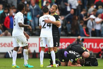 SWANSEA, WALES - SEPTEMBER 11:  Jack Cork of Swansea City and Branislav Ivanovic of Chelsea embrace as John Terry of Chelsea is given treatment after the Premier League match between Swansea City and Chelsea at Liberty Stadium on September 11, 2016 in Swa
