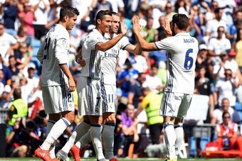 Real Madrid's Portuguese forward Cristiano Ronaldo (C) celebrates with teammates after scoring during the Spanish league football match Real Madrid CF vs CA Osasuna at the Santiago Bernabeu stadium in Madrid on September 10, 2016. / AFP / GERARD JULIEN   