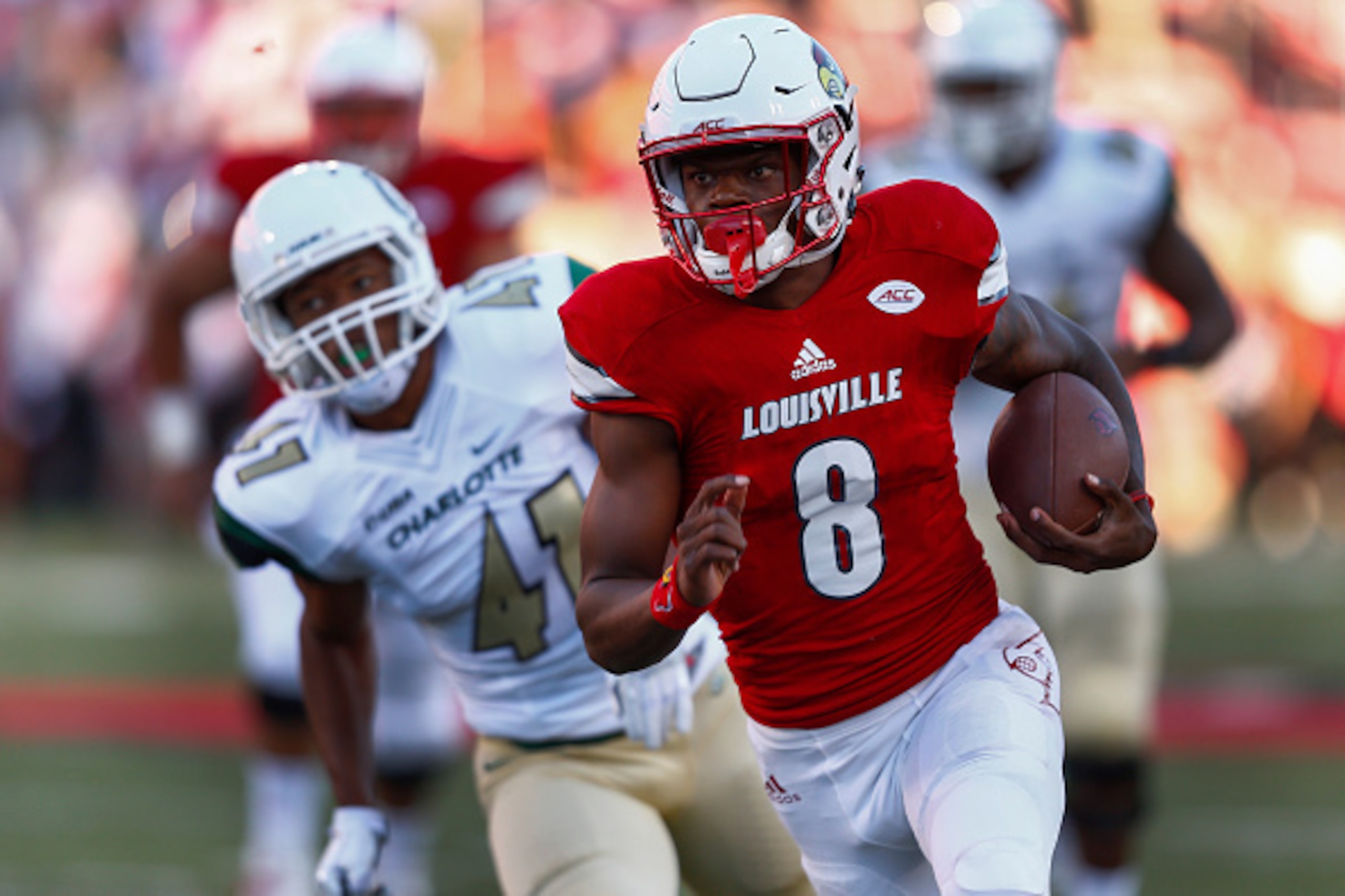 LOUISVILLE, KY - SEPTEMBER 01: Lamar Jackson #8 of the Louisville Cardinals runs the ball for a touchdown as AJ McDonald #41 of the Charlotte 49ers follows at Papa John's Cardinal Stadium on September 1, 2016 in Louisville, Kentucky.  (Photo by Michael Hi