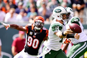 EAST RUTHERFORD, NJ - SEPTEMBER 11:  Ryan Fitzpatrick #14 of the New York Jets gets rid of the ball under pressure from Michael Johnson #90 of the Cincinnati Bengals during the second quarter at MetLife Stadium on September 11, 2016 in East Rutherford, Ne