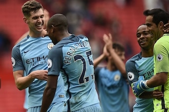 Manchester City's English defender John Stones (L) and Manchester City's Brazilian midfielder Fernandinho (2nd L) celebrate on the pitch after the English Premier League football match between Manchester United and Manchester City at Old Trafford in Manch