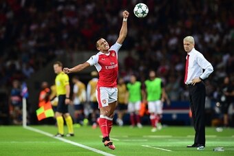 Arsenal's Chilean forward Alexis Sanchez (C) reacts next to Arsenal's French manager Arsene Wenger (R) during the UEFA Champions League Group A football match between Paris-Saint-Germain vs Arsenal FC, on September 13, 2016 at the Parc des Princes stadium