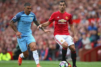 MANCHESTER, ENGLAND - SEPTEMBER 10: Henrikh Mkhitaryan of Manchester United (R) takes the ball past Aleksander Kolorov of Manchester City (L) during the Premier League match between Manchester United and Manchester City at Old Trafford on September 10, 20