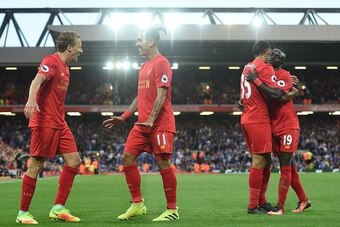 Liverpool's Brazilian midfielder Roberto Firmino (2nd L) celebrates with Liverpool's Brazilian midfielder Lucas Leiva (L) as Liverpool's English defender Kevin Stewart embraces Liverpool's Senegalese midfielder Sadio Mane (R) after Firmino scores their fo