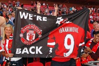 Manchester United fans celebrate after Manchester United beat Leicester City to win the FA Community Shield football match at Wembley Stadium in London on August 7, 2016.  / AFP / Ian Kington / NOT FOR MARKETING OR ADVERTISING USE / RESTRICTED TO EDITORIA