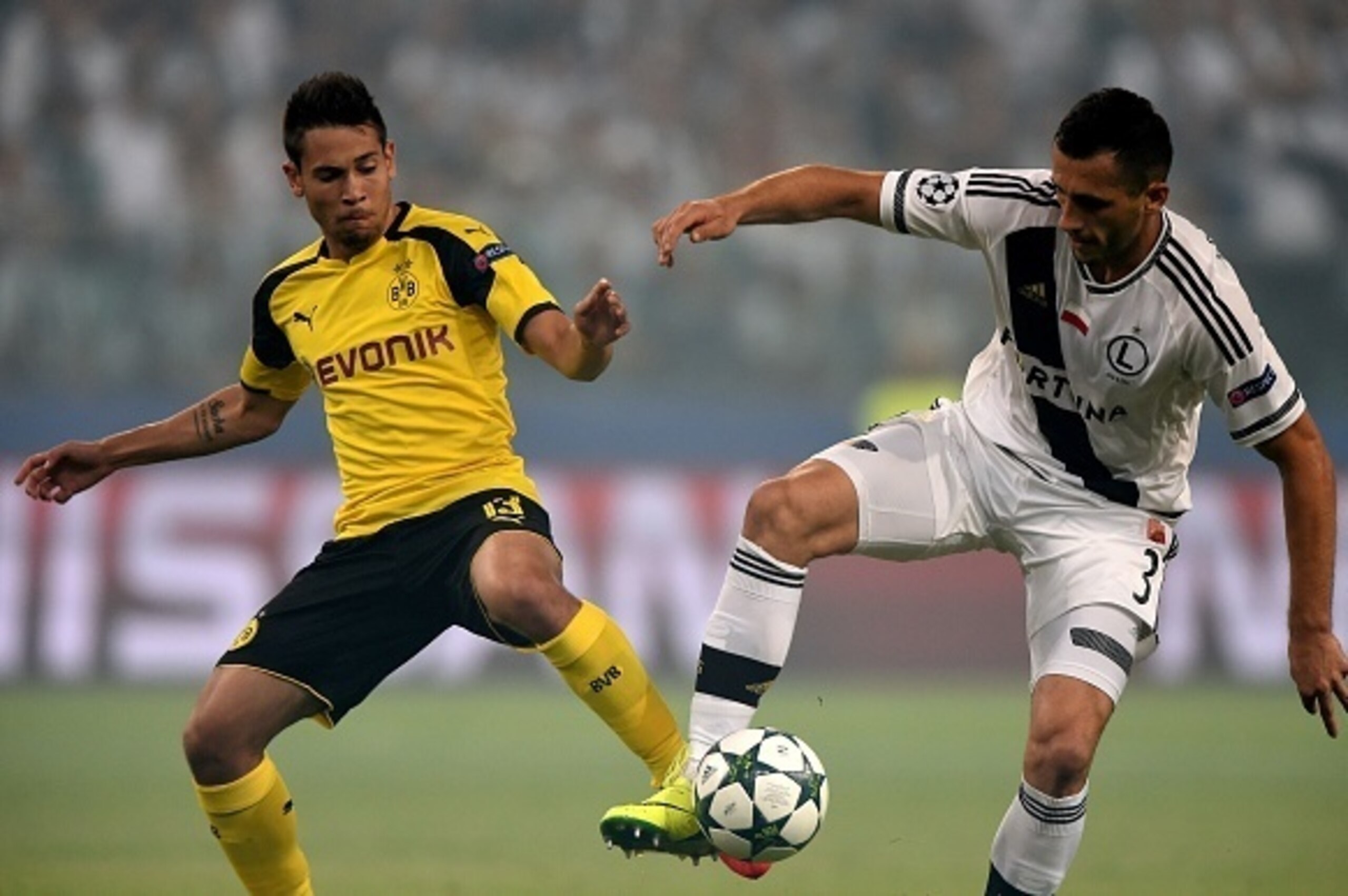 Dortmund's Portuguese defender Raphael Guerreiro (L) and Legia Warsaw's midfielder Tomasz Jodlowiec vie for the ball during the UEFA Champions League group F football match Legia Warsaw v Borussia Dortmund at the Legia stadium in Warsaw on September 14, 2