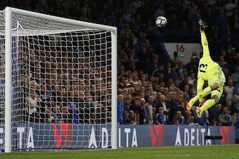 Chelsea's Belgian goalkeeper Thibaut Courtois jumps but fails to to save a long-range shot from Liverpool's English midfielder Jordan Henderson to score his team's second goal during the English Premier League football match between Chelsea and Liverpool 