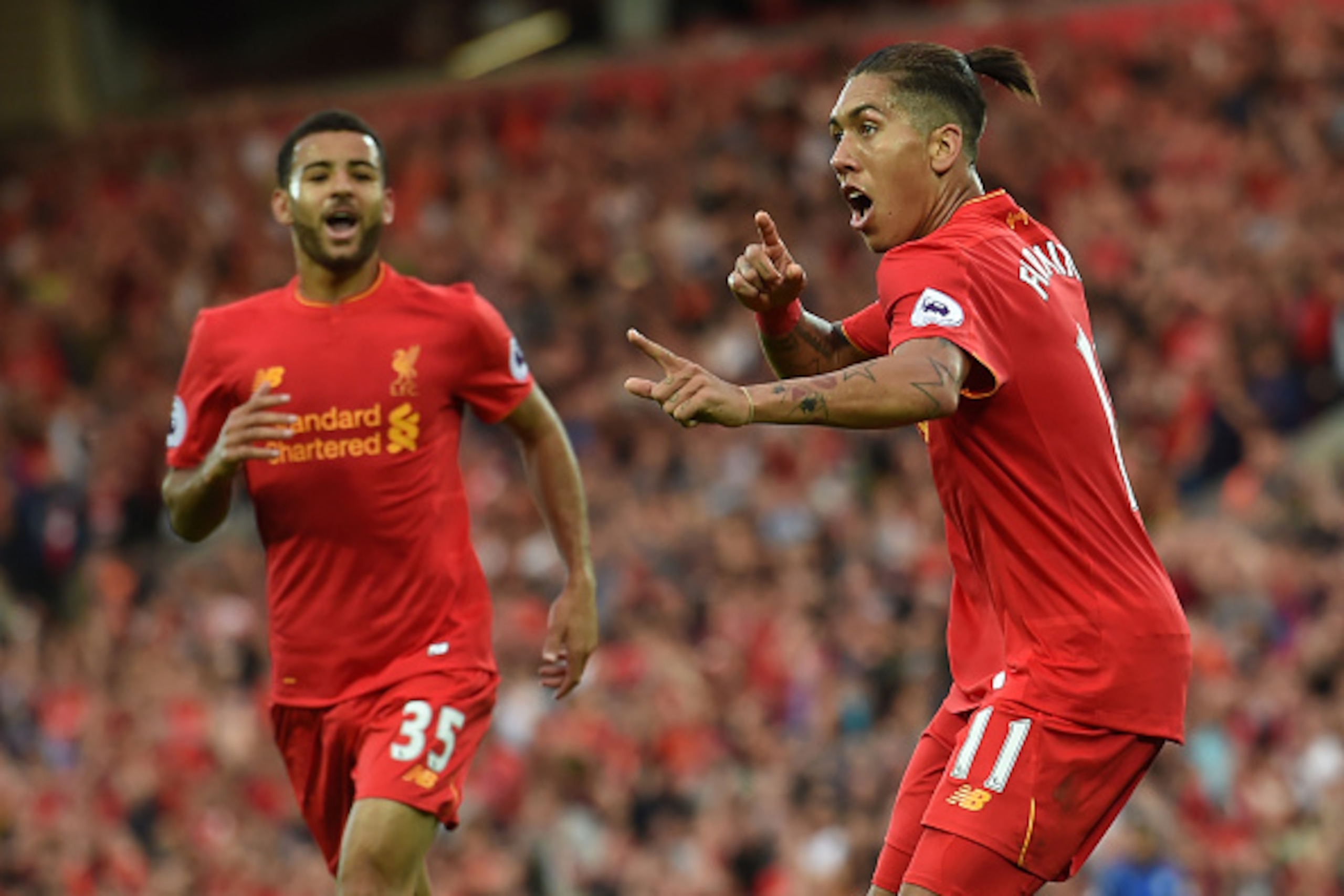 Liverpool's Brazilian midfielder Roberto Firmino (R) celebrates after scoring their fourth goal during the English Premier League football match between Liverpool and Leicester City at Anfield in Liverpool, north west England on September 10, 2016. / AFP 