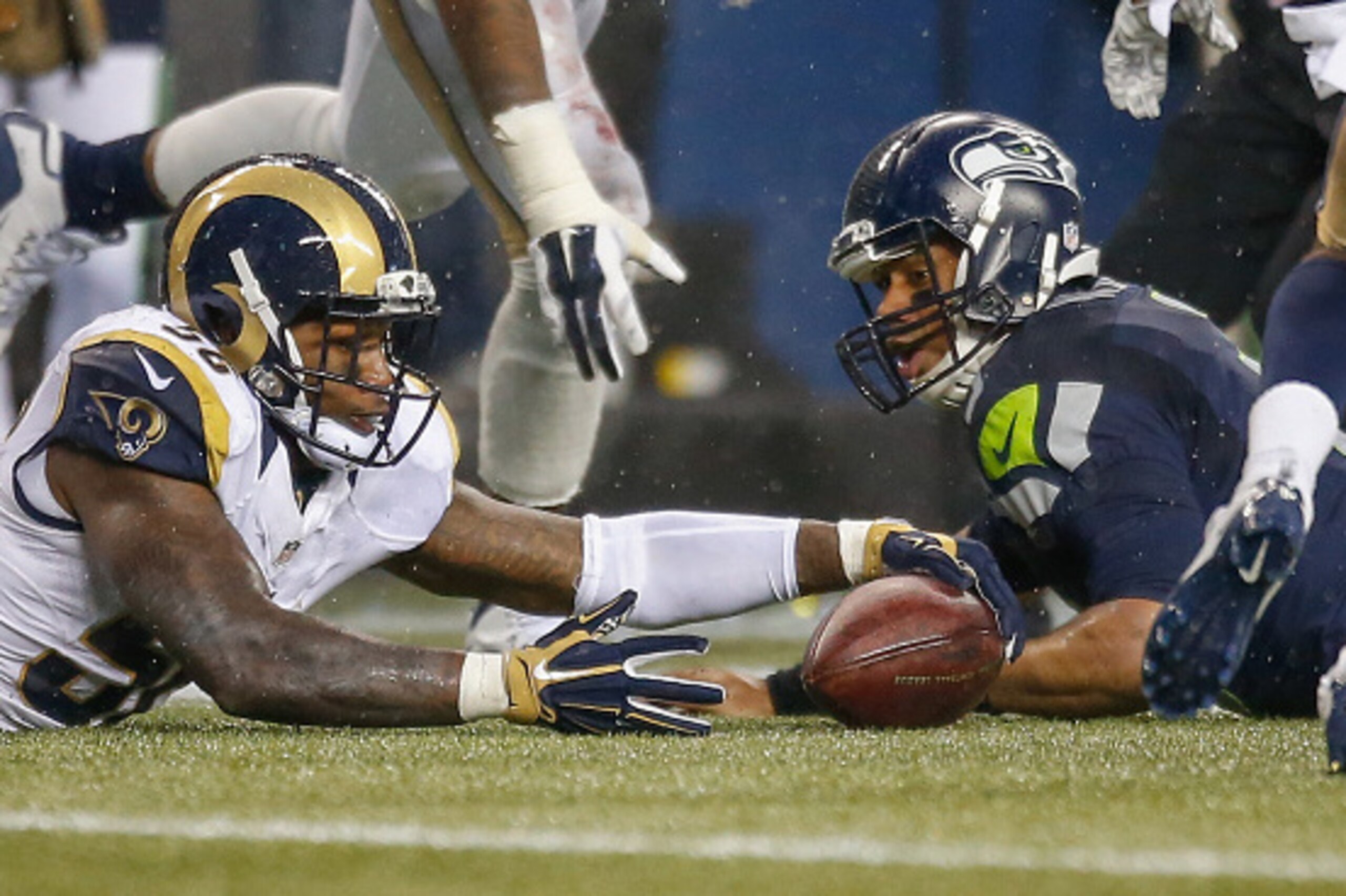 SEATTLE, WA - DECEMBER 27:  Quarterback Russell Wilson #3 of the Seattle Seahawks fumbles as linebacker Akeem Ayers #56 of the St. Louis Rams recovers with under two minutes to play at CenturyLink Field on December 27, 2015 in Seattle, Washington.  The Ra