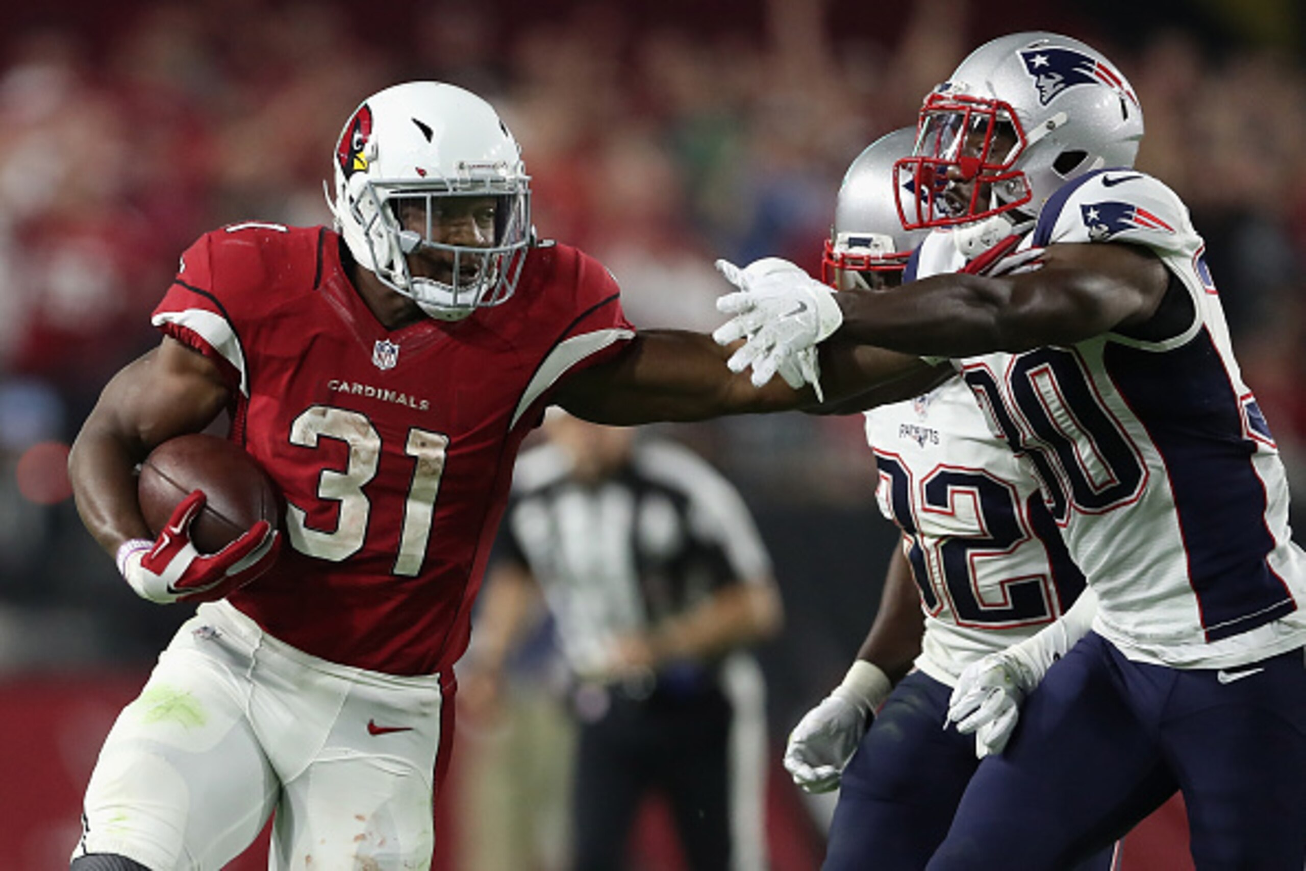 GLENDALE, AZ - SEPTEMBER 11:  Running back David Johnson #31 of the Arizona Cardinals rushes the football past free safety Devin McCourty #32 and free safety Duron Harmon #30 of the New England Patriots during the NFL game at the University of Phoenix Sta