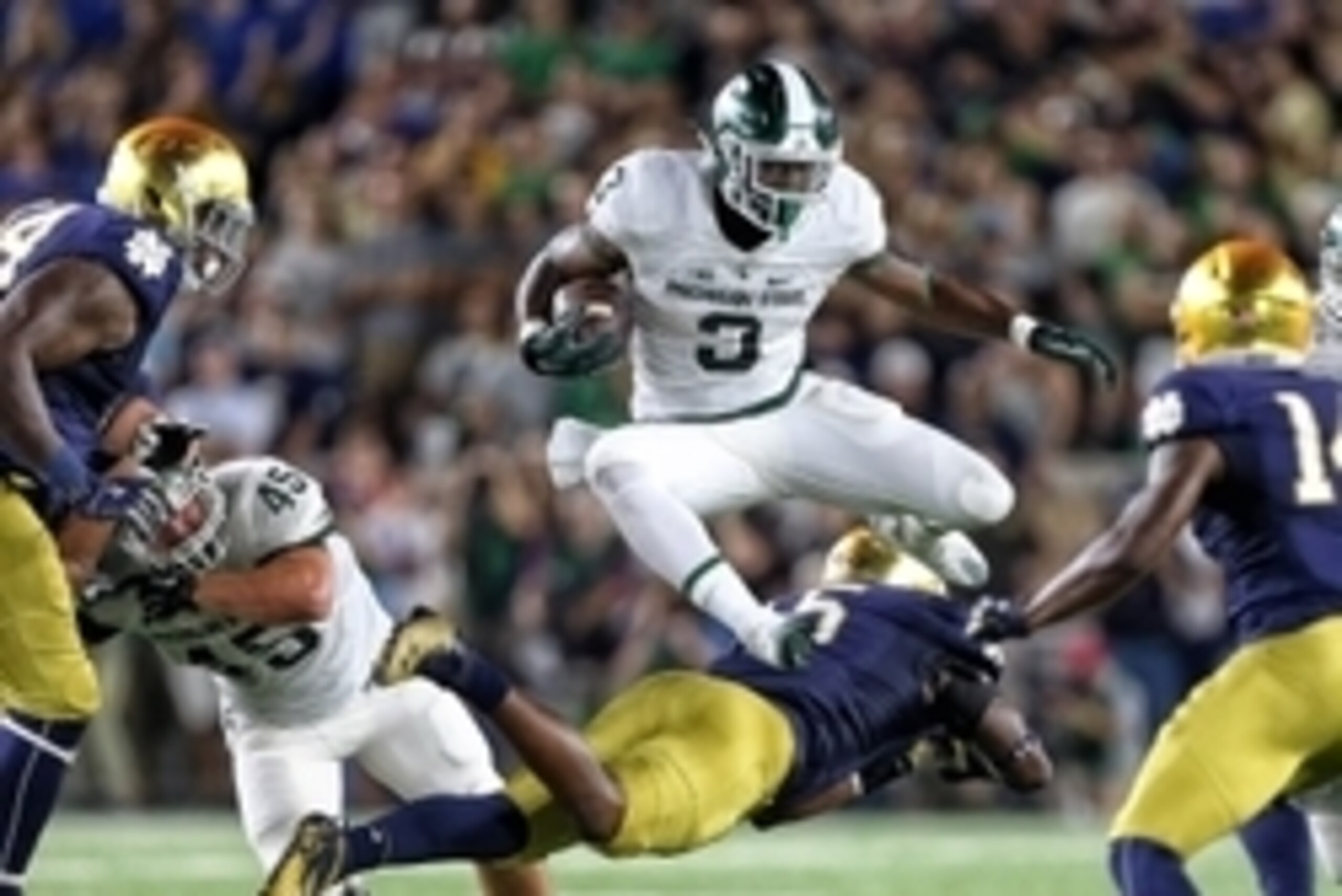 Sep 17, 2016; South Bend, IN, USA;  Michigan State Spartans running back LJ Scott (3) leaps over Notre Dame Fighting Irish linebacker Nyles Morgan (5) during the first half a game at Notre Dame Stadium. Mandatory Credit: Mike Carter-USA TODAY Sports