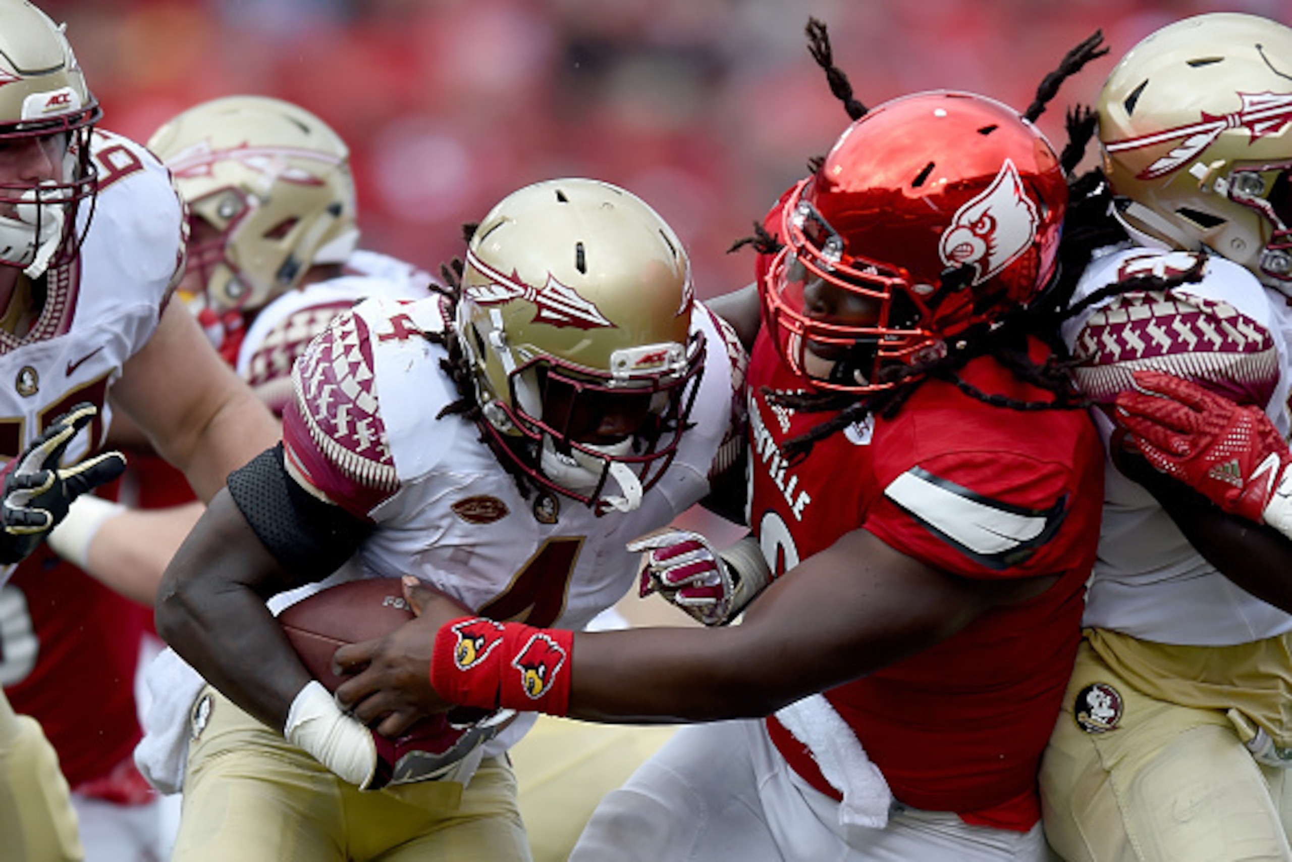 LOUISVILLE, KY - SEPTEMBER 17: Dalvin Cook #4 of the Florida State Seminoles is tackled during the fourth quarter of the game against the Louisville Cardinals at Papa John's Cardinal Stadium on September 17, 2016 in Louisville, Kentucky. (Photo by Bobby E