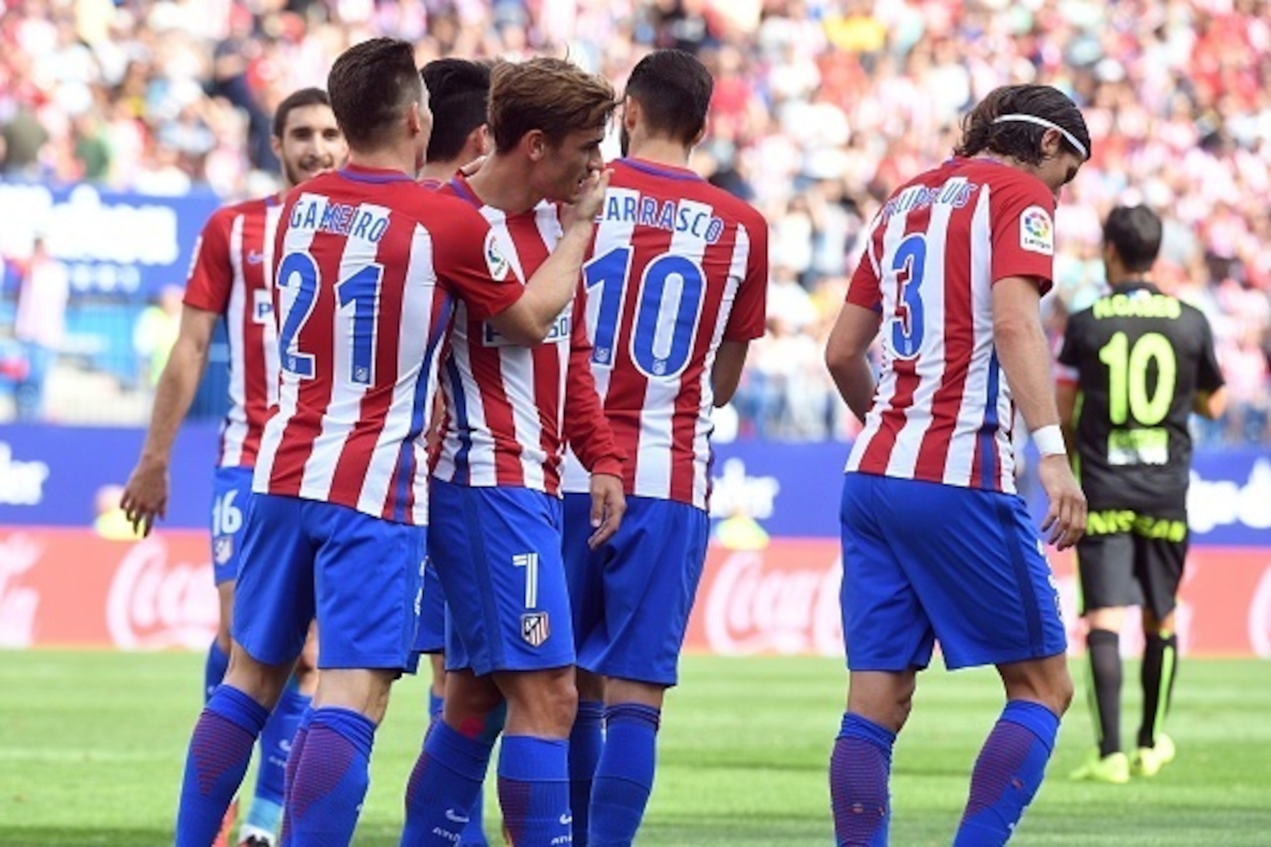 Atletico Madrid's French forward Antoine Griezmann (2ndL) is congratulated by his teammates after scoring during the Spanish league football match Club Atletico de Madrid vs Real Sporting de Gijon at the Vicente Calderon stadium in Madrid on September 17,
