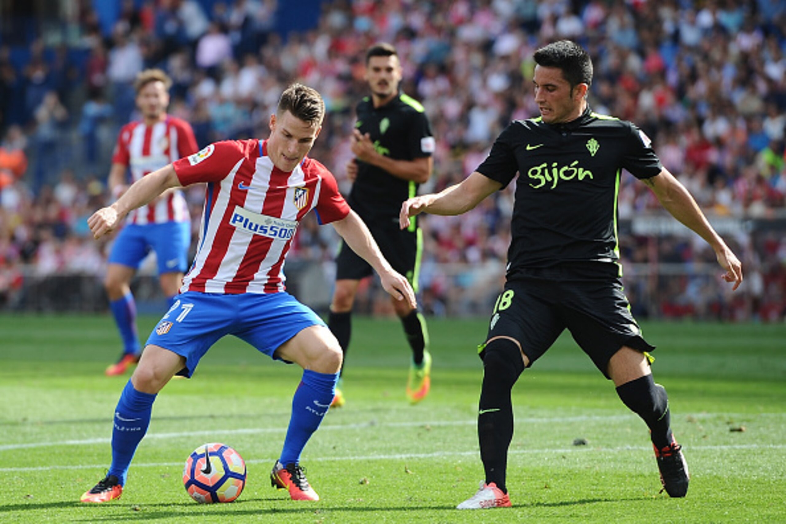 MADRID, SPAIN - SEPTEMBER 17:   Kevin Gameiro of Club Atletico de Madrid tries to get past Isma Lopez of  Real Sporting de Gijon during the La Liga match between Club Atletico de Madrid and Real Sporting de Gijon at Vicente Calderon Stadium on September 1